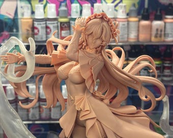 Puede incluir: Figura sin pintar de un personaje femenino con cabello largo y suelto y un tocado decorativo. La figura está en una pose dinámica, con tela fluida y una estructura de soporte translúcida. La figura es de color melocotón.