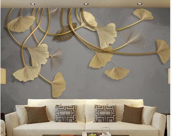 Puede incluir: Un sofá blanco con cojines dorados se encuentra frente a una pared gris con un diseño de hojas doradas. Las hojas están dispuestas en un patrón fluido y recuerdan a un árbol de ginkgo.