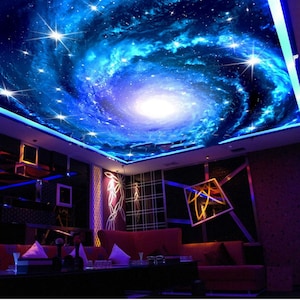 May include: A room featuring a ceiling mural of a swirling galaxy with bright stars and a central white light. The room has red sofas, dark walls, and decorative lighting.