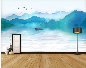 May include: A watercolor painting of a mountain range with a lake in the foreground. The mountains are painted in shades of blue and green, and the lake is a light blue. A small boat is in the lake, and there are birds flying in the sky.