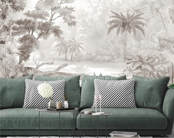 Puede incluir: Un sofá verde con dos almohadas a rayas blancas y negras y dos mesas auxiliares negras. El sofá está frente a una pared con una impresión en blanco y negro de una escena de bosque tropical.