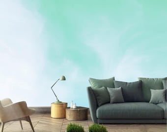 Könnte beinhalten: Eine grün-weiße Ombre-Wand mit einem grauen Sofa, zwei Beistelltischen und einer Stehlampe. Das Sofa hat mehrere Kissen und steht vor der Wand. Die Beistelltische sind aus Holz und haben ein rustikales Aussehen. Die Stehlampe ist aus Metall und hat ein schlichtes Design.