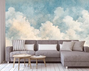 Könnte beinhalten: Ein graues Ecksofa mit weißen und schwarzen gestreiften Kissen vor einer Wandmalerei, die ein Aquarellbild eines blauen Himmels mit weißen Wolken darstellt.