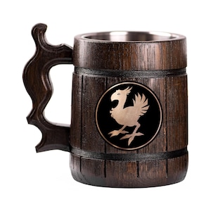 May include: A dark brown wooden beer mug with a decorative handle. The mug features a metal interior and a circular emblem with a gold-colored bird design on a black background. The mug is approximately 6 inches tall.