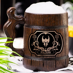May include: A wooden beer mug filled with beer and foam. The mug has a dark brown finish and a decorative label with the word "PALADIN". The handle is intricately carved.