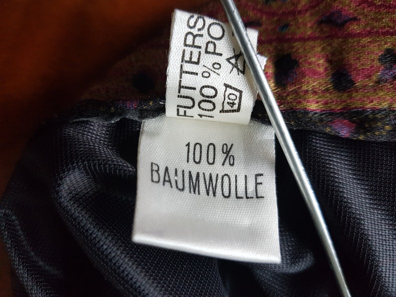 May include: White fabric label with black text that reads "FUTTERS 100% POLY 40" and "100% BAUMWOLLE".