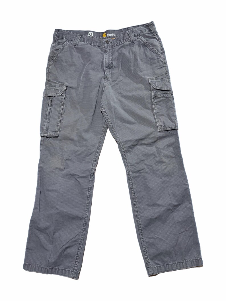 Pu&ograve; includere: Pantaloni cargo grigi Carhartt dalla vestibilit&agrave; rilassata. I pantaloni hanno pi&ugrave; tasche, tra cui due tasche cargo sui lati. Sono realizzati in un materiale resistente e hanno una vestibilit&agrave; rilassata. Il logo Carhartt &egrave; visibile in vita.