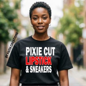 May include: Black t-shirt with the text "PIXIE CUT LIPSTICK & SNEAKERS" in white and red lettering. The words are stacked on top of each other. The words "BY FAITH CREATIONS" are printed vertically on the left side of the shirt.