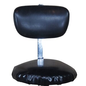 May include: A black vinyl swivel chair with a chrome base and five wheels. The chair has a padded seat and a headrest.