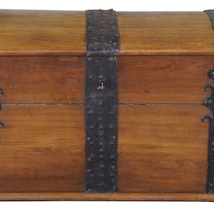 May include: A large, wooden chest with iron banding and decorative iron accents. The chest has a hinged lid and a lock.