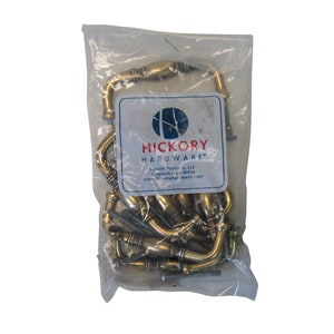 May include: A clear plastic bag filled with brass cabinet pulls. The bag has a label that reads "Hickory Hardware" with the company's website address and contact information.