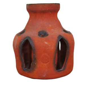 May include: A terracotta pot with a unique design featuring cut-out shapes and a textured surface. The pot is a reddish-brown color with black accents.
