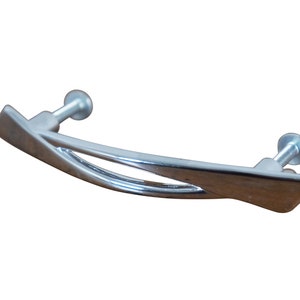 May include: A silver-toned cabinet pull with a curved, modern design. The pull has two screw holes for installation.