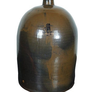 May include: A brown glazed stoneware crock with a rounded body and a narrow opening. The crock has a number "4" painted on the front.