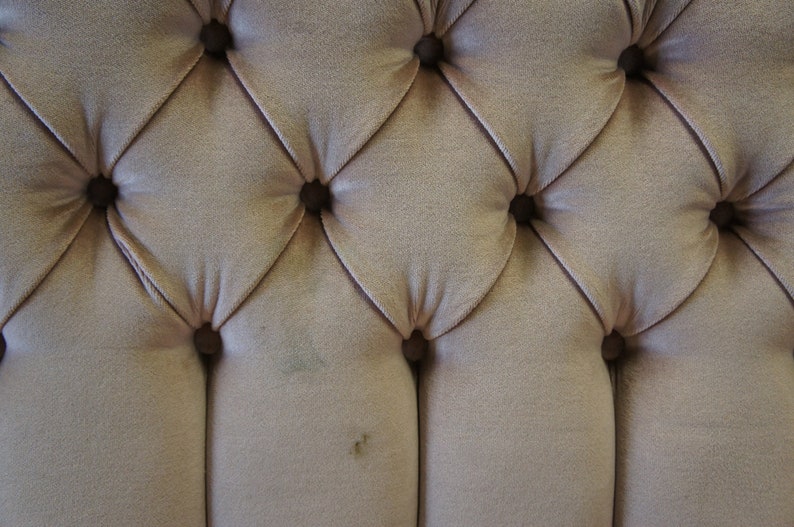 Peut inclure: Gros plan sur un tissu capitonn&eacute; brun clair avec un motif en losange. Le tissu a un l&eacute;ger brillant et est accentu&eacute; par de petits boutons ronds.