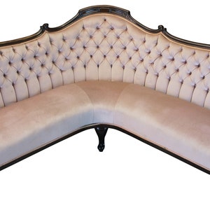 Peut inclure: Un grand canap&eacute; d'angle incurv&eacute; avec un rev&ecirc;tement en tissu beige clair capitonn&eacute; et une structure en bois brun fonc&eacute;. Le canap&eacute; a un design traditionnel et orn&eacute; avec des d&eacute;tails sculpt&eacute;s sur les accoudoirs et les pieds.