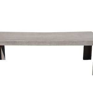 May include: A rectangular, light gray concrete coffee table with a slightly curved top. The table has four square legs and is designed for outdoor or indoor use. The table measures approximately 60 inches long.