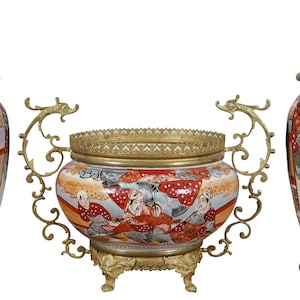 May include: A set of three antique Japanese porcelain lamps with gold accents. The lamps feature intricate hand-painted designs of figures in traditional clothing. The lamps are mounted on ornate brass bases with dragon-shaped handles.