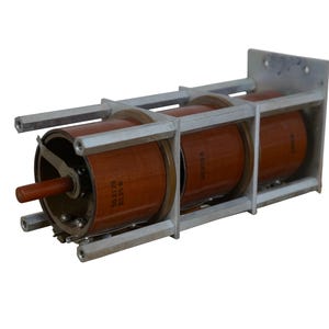 May include: Three brown cylindrical electrical components mounted in a metal frame. The components are labeled with the text "MADE IN USSR".