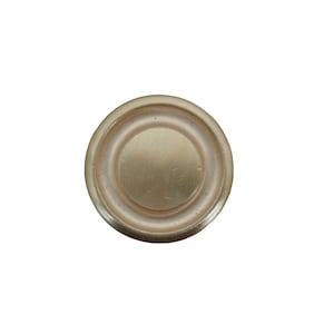 May include: A round, gold-colored metal finial with a raised, concentric circle design.