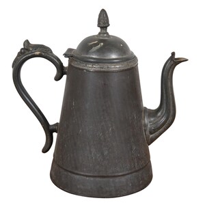 May include: Antique pewter teapot with a dark gray finish. The teapot features a curved spout, a decorative handle, and a lid with a small finial. The design is reminiscent of vintage kitchenware.