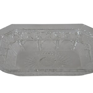 May include: A clear glass serving dish with an octagonal shape and intricate cut-glass design.