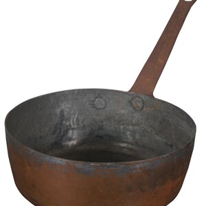 May include: A vintage copper pot with a long handle. The pot has a worn, aged patina and is suitable for cooking or display.