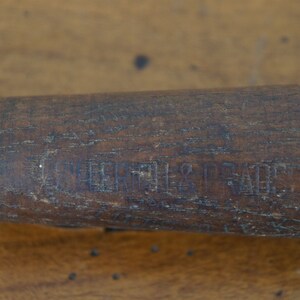 May include: Close-up of a wooden baseball bat with the text "Louisville Slugger" engraved on the side.