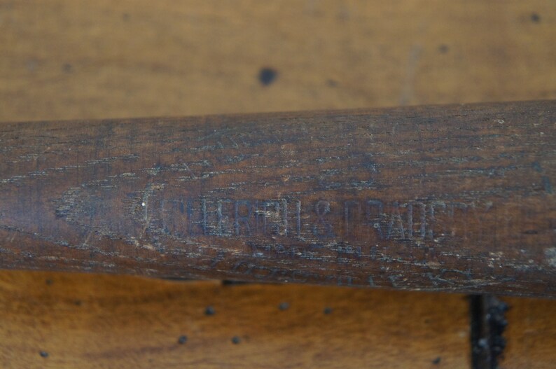 May include: Close-up of a wooden baseball bat with the text "Louisville Slugger" engraved on the side.
