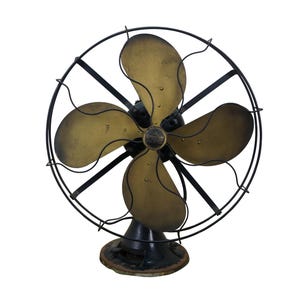 Puede incluir: Un ventilador el&eacute;ctrico antiguo con cuatro aspas de color lat&oacute;n y un marco de metal negro. El ventilador tiene una jaula circular y una base negra. Las aspas son curvas y tienen p&aacute;tina. Un art&iacute;culo de decoraci&oacute;n vintage.