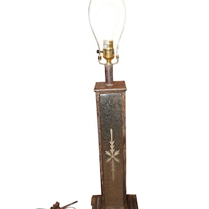 May include: A tall, brown table lamp with a clear glass shade and a gold-colored base. The base has a decorative etched design.