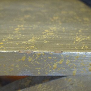 K&ouml;nnte beinhalten: Nahaufnahme einer silbernen Oberfl&auml;che mit einer gesprenkelten goldenen Oberfl&auml;che. Die Oberfl&auml;che hat einen leichten Glanz und scheint aus Metall zu sein.