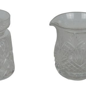 May include: A clear glass sugar bowl with a lid and a clear glass creamer. Both pieces have a cut glass design.