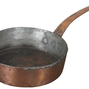 May include: A vintage copper saucepan with a long handle. The saucepan has a worn, aged patina and is suitable for cooking on a stovetop.