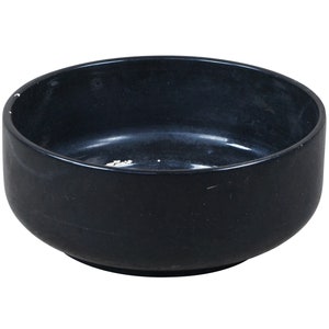 May include: A black ceramic bowl with a smooth, rounded interior. The bowl is empty and has a slight sheen.
