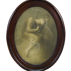 May include: An oval-shaped framed print featuring a figure in a flowing gown, seated and leaning on a harp-like instrument. The frame is dark brown, and the print has a sepia-toned color palette.