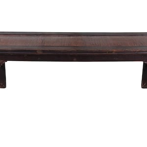 May include: A dark brown wooden bench with a woven top and carved details on the legs.