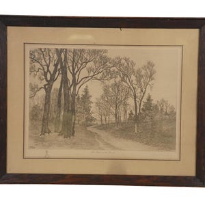 May include: A framed landscape print featuring a winding dirt road through a forest of bare trees. The artwork is in grayscale, with a light beige mat and a dark brown wooden frame. The print has a vintage aesthetic.