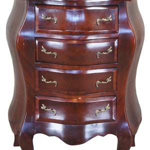 May include: A mahogany chest of drawers with a green marble top and four drawers with ornate brass handles. The chest has a curved front and legs.