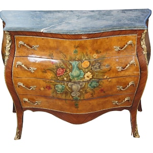 May include: A French-style chest of drawers with a marble top and four drawers. The drawers are decorated with floral designs and gold accents. The chest is made of wood and has a curved front.