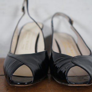 May include: A pair of black peep-toe heeled shoes with slingback straps.