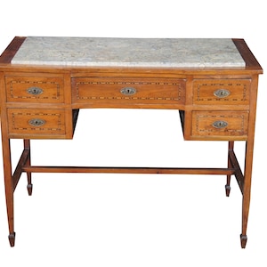 May include: A wooden desk featuring a rectangular marble top with a mottled grey and white pattern. The desk includes five drawers with inlaid wood borders and oval metal keyhole plates. It stands on four straight legs with a connecting stretcher.