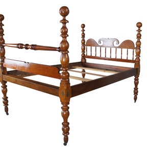 May include: A vintage wooden four-poster bed frame with a warm brown finish. The bed features ornate turned posts, a headboard with a decorative cutout, and a footboard. The frame is designed to accommodate a mattress and box spring.