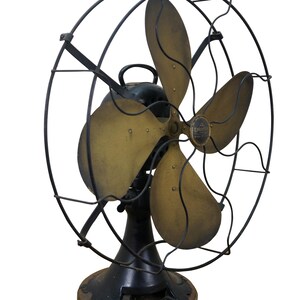 Puede incluir: Ventilador el&eacute;ctrico antiguo con cuatro aspas de color lat&oacute;n y una estructura de metal negro. El ventilador tiene una base negra y un asa. Las aspas est&aacute;n ligeramente curvadas, lo que sugiere un dise&ntilde;o vintage.
