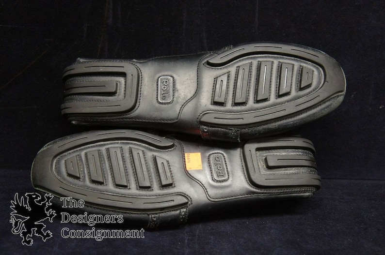 May include: A pair of black leather loafers with a textured rubber sole. The loafers have the word "Polo" embossed on the side.