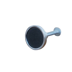 May include: A silver curtain rod finial with a black round knob.