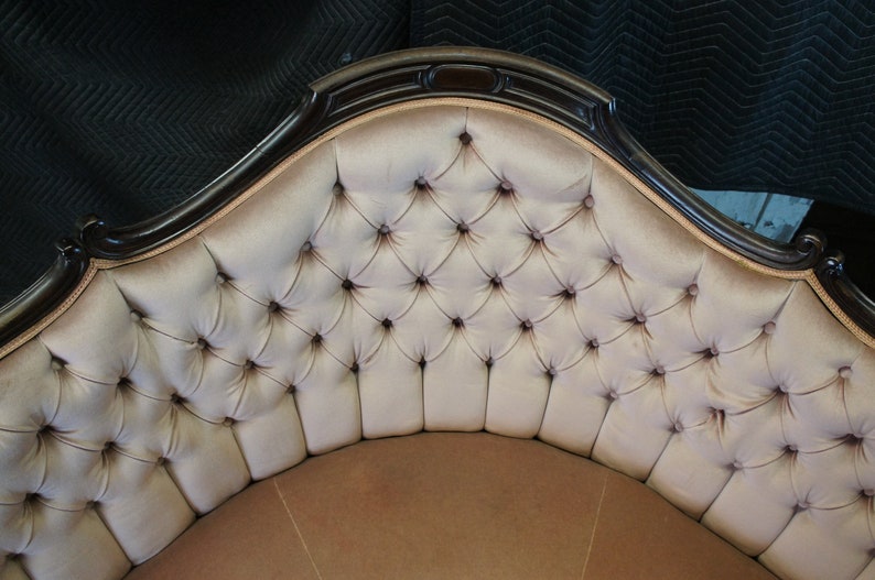 Peut inclure: Un canap&eacute; en velours cr&egrave;me capitonn&eacute; et incurv&eacute; avec une structure en bois fonc&eacute;. Le canap&eacute; pr&eacute;sente un motif de capitonnage en forme de diamant.