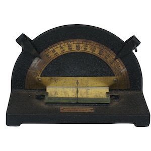 May include: A black metal protractor with a brass protractor and a brass level. The protractor has markings from 0 to 180 degrees.