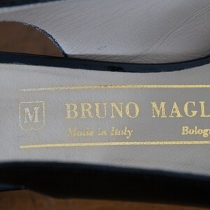 May include: Close-up of the inside of a black leather shoe with a gold label that reads "BRUNO MAGLI Made in Italy Bologna".