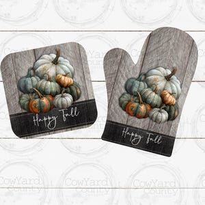 May include: Two grey and brown oven gloves with a woodgrain pattern and a pile of green and white pumpkins. The oven gloves have the text "Happy Fall" printed on them.
